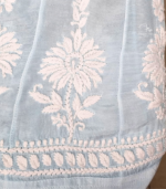 Powder blue Muslin co-ord set featuring white hand-embroidered Lucknowi Chikankari, an A-line flared top with bell sleeves, white lace detailing and matching wide-leg palazzo pants.